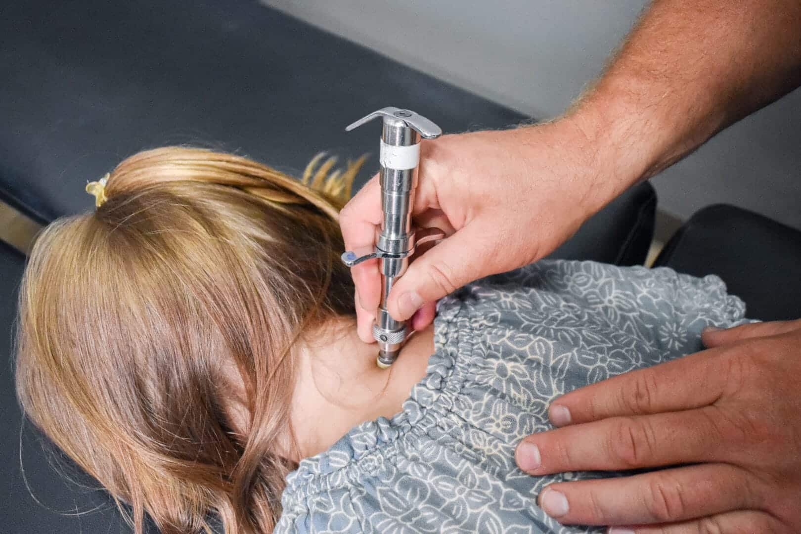 An Authority Chiropractic doctor giving a child a precise, low-force adjustment